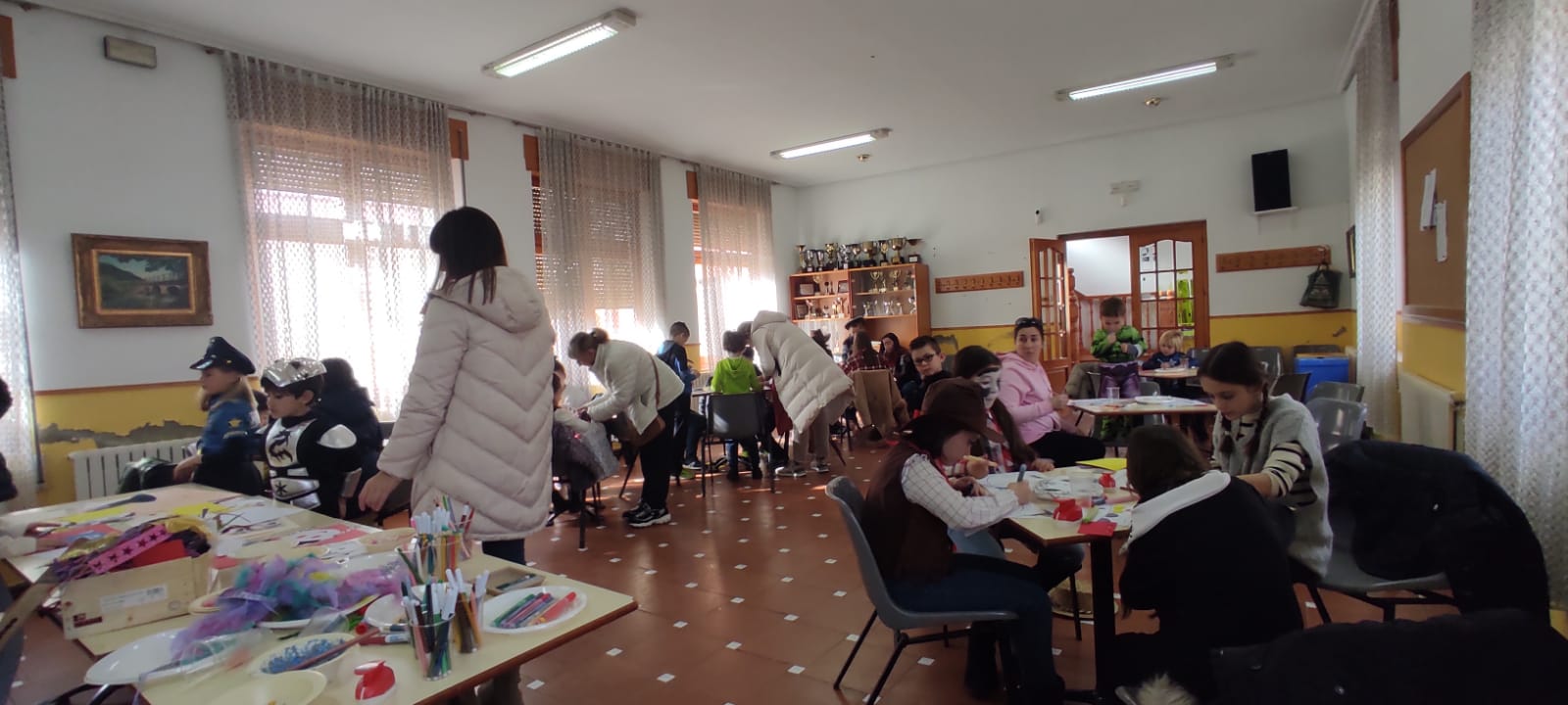 Panorámica de la sala con niños haciendo el taller de carnaval.
