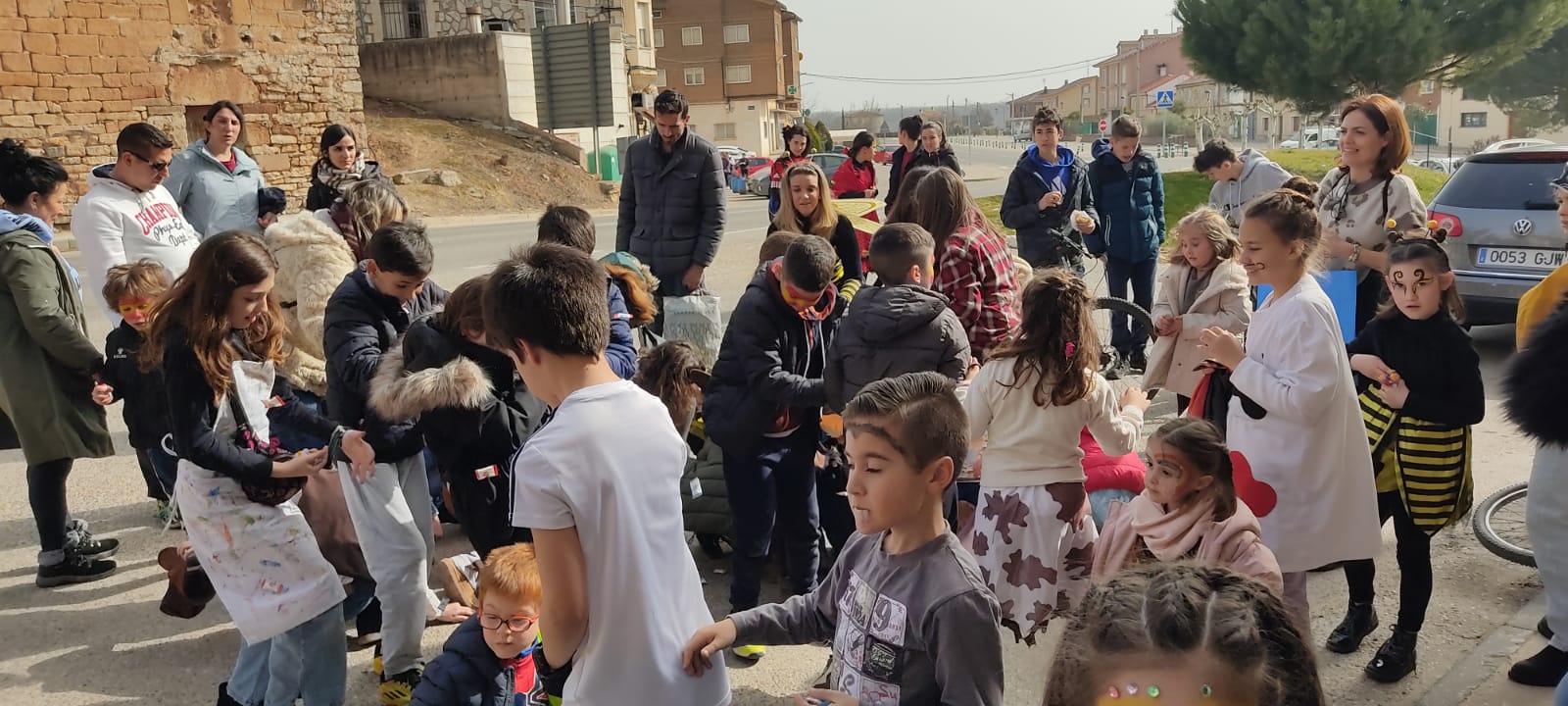 Niños cogiendo caramelos en los comercios durante el pasacalles en Tardajos.